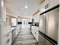 Spacious kitchen featuring stainless steel appliances, white cabinets, and a large countertop at 3211 Oaktree Park Dr, Lawrenceville, GA 30044