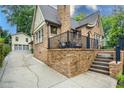 Brick home showcasing a backyard entrance with steps, a balcony, and a detached two-car garage at 2580 Acorn Ne Ave, Atlanta, GA 30305