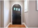 Interior shot of a black arched wooden front door with sidelight, wainscoting, and hardwood floors at 2580 Acorn Ne Ave, Atlanta, GA 30305