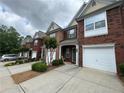 Traditional brick townhomes featuring attached garages and driveway at 3871 Pleasant Oaks Dr, Lawrenceville, GA 30044