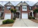Traditional brick townhome featuring attached garage and manicured landscaping at 3871 Pleasant Oaks Dr, Lawrenceville, GA 30044