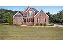 Well-maintained brick home on a large lot with a green lawn and neat landscaping at 400 Kyle Ct, Fayetteville, GA 30215
