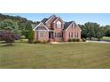 Beautiful two-story brick home with a manicured lawn and mature trees at 400 Kyle Ct, Fayetteville, GA 30215