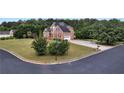 Charming brick home on a corner lot with a lush green lawn and mature trees at 400 Kyle Ct, Fayetteville, GA 30215