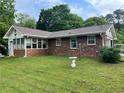 Brick exterior showing the side and back of the home with a grassy yard space and mature trees at 2659 Odum St, Snellville, GA 30078