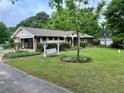 Landscaped front yard featuring a quaint swing and lush greenery complementing this charming brick home at 2659 Odum St, Snellville, GA 30078