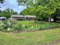 Spacious front yard with flower beds and mature trees adding natural beauty to this charming brick home at 2659 Odum St, Snellville, GA 30078