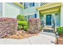 Inviting front entrance with manicured bushes, walkway lighting, and a welcoming wreath on the front door at 2727 Lost Mill Trce, Buford, GA 30519
