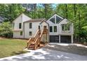 Contemporary home with striking design and black garage doors nestled among mature trees and lush landscaping at 3880 Northpoint Dr, Marietta, GA 30062