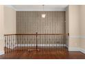Open hallway features iron railing, decorative wall trim, hanging light fixture and shining wood floors at 4656 Ivygate Se Cir, Atlanta, GA 30339