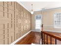 Inviting hallway with wood floors, and stylish wall trim and hanging light fixture, leading to a bright front door at 4656 Ivygate Se Cir, Atlanta, GA 30339