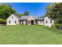 Stately home with a manicured lawn, stone and siding facade, and classic architectural details at 4785 Brinkley Ln, Atlanta, GA 30342