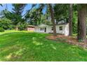 Beautifully landscaped front yard with mature trees, showcasing a well-maintained white brick home at 1660 Mallard Cir, Conley, GA 30288