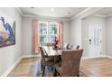 Well-lit dining room with hardwood floors, modern decor, and a view of the outdoors at 2436 Hidden Creek Road, Kennesaw, GA 30152