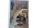 Welcoming foyer with a curved staircase, chandelier, and elegant marble-topped table at 999 Ashebrooke Ne Way, Marietta, GA 30068