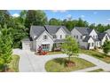 Beautiful two-story home with a circular driveway, attached garage, manicured lawn, and lush landscaping at 107 Owens Mill Place, Canton, GA 30115
