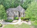 Majestic home showcasing meticulous landscaping, winding walkway, and verdant trees at 1455 Lockridge Dr, Cumming, GA 30041