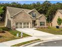 Charming brick home, well-manicured lawn, two-car garage, surrounded by lush greenery and mature trees at 3425 Linstead Ct, Loganville, GA 30052