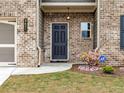Inviting front entrance with brick facade, black front door, and an ADT security system sign at 3425 Linstead Ct, Loganville, GA 30052