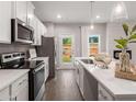 Well-equipped kitchen with stainless steel appliances, quartz countertops, ample cabinet space, and an adjacent backyard view at 5623 Hislop Ln # 84, Mableton, GA 30126