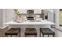 Bright kitchen with quartz countertops, stainless appliances, modern fixtures and stylish seating at the kitchen island at 5623 Hislop Ln # 84, Mableton, GA 30126
