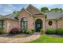 Inviting front entrance with brick facade, arched windows, and lush landscaping at 710 Eastbourne Ct, Alpharetta, GA 30005