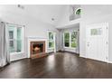 Inviting living room featuring a brick fireplace, hardwood floors, and large windows that provide ample light at 969 Oak Sw St, Atlanta, GA 30310