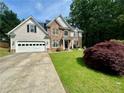 Charming two-story home featuring stone and shingle siding, well-manicured lawn, and an attached two-car garage at 1782 Telfair Chase Way, Lawrenceville, GA 30043