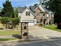 Charming two-story home featuring stone and shingle siding, well-manicured lawn, and long concrete driveway at 1782 Telfair Chase Way, Lawrenceville, GA 30043