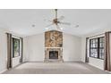 Spacious living room featuring a stone fireplace, vaulted ceiling, and ample natural light at 1147 Williamsburg Ln, Norcross, GA 30093