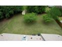 Aerial view of a large, green backyard with mature trees and a small storage shed at 205 Summer Walk Dr, Covington, GA 30016