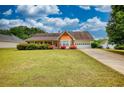 Charming home with manicured lawn, colorful flower bushes, and attached two-car garage at 205 Summer Walk Dr, Covington, GA 30016