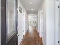 Inviting entryway with hardwood floors and white walls, leading to the kitchen at 1341 Midnight Ride Ct, Hampton, GA 30228