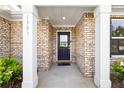 Close-up of the front door entrance featuring white columns and brick surround at 1341 Midnight Ride Ct, Hampton, GA 30228