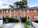 Two-story brick townhome showcasing colorful shutters, mature landscaping, and convenient parking at 1038 Westfield Se Trce, Smyrna, GA 30082