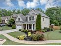 Attractive home featuring manicured landscaping, a lush lawn, and a welcoming covered entryway at 2376 Roberts View Trail, Buford, GA 30519