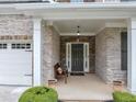 Inviting front porch and entry with stone accents, a seating area, and classic design details at 2376 Roberts View Trail, Buford, GA 30519