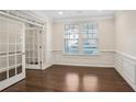 Bright living room with hardwood floors, white wainscoting and trim, and natural light at 5195 Belmore Manor Ct, Suwanee, GA 30024