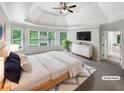 Staged main bedroom with a tray ceiling, lots of natural light, and ensuite bathroom at 9979 Bridgewater Pointe, Villa Rica, GA 30180