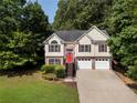 Beautiful two-story home featuring a brick accent, a bright red front door, and a neatly kept front yard at 136 Walkers Pond Dr, Villa Rica, GA 30180