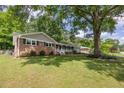 Well-maintained home with brick accents, a landscaped yard, and a large shade tree at 1732 Samaria Trl, Tucker, GA 30084