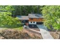 Aerial view of a two-story home showcasing driveway, yard, and surrounding trees at 1129 Pinehurst Rd, Grayson, GA 30017