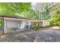 Inviting white brick home featuring an open carport and cozy front porch with seating at 3294 Mcclure Bridge Rd, Duluth, GA 30096