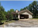 View of the house and carport showing the backyard trees at 7260 Cox Rd, Cumming, GA 30028