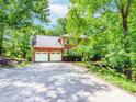Charming two-story brick home featuring a spacious driveway and a two-car garage surrounded by lush trees at 1463 Shadowrock Hts, Marietta, GA 30062