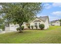 Well-manicured front yard featuring a large tree, green grass, and tastefully trimmed bushes at 436 Berkshire Pl, Fairburn, GA 30213