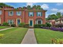 Inviting brick townhouse with lush green lawn and colorful purple landscaping at 6139 Keswick Row, Tucker, GA 30084