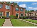 Charming brick townhouse featuring a well-manicured lawn and tasteful landscaping at 6139 Keswick Row, Tucker, GA 30084