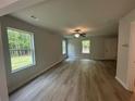 Bright living room with large windows offering scenic views and laminate floors illuminated by ceiling fan at 25 Emerald Ln, Covington, GA 30014