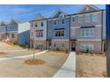 Attractive townhomes showcasing brick and siding details, complemented by lush landscaping at 1258 Ainsworth Aly # 46, Sugar Hill, GA 30518